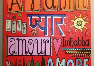 The word 'Love' in many languages painted with bright colors on wood in red background